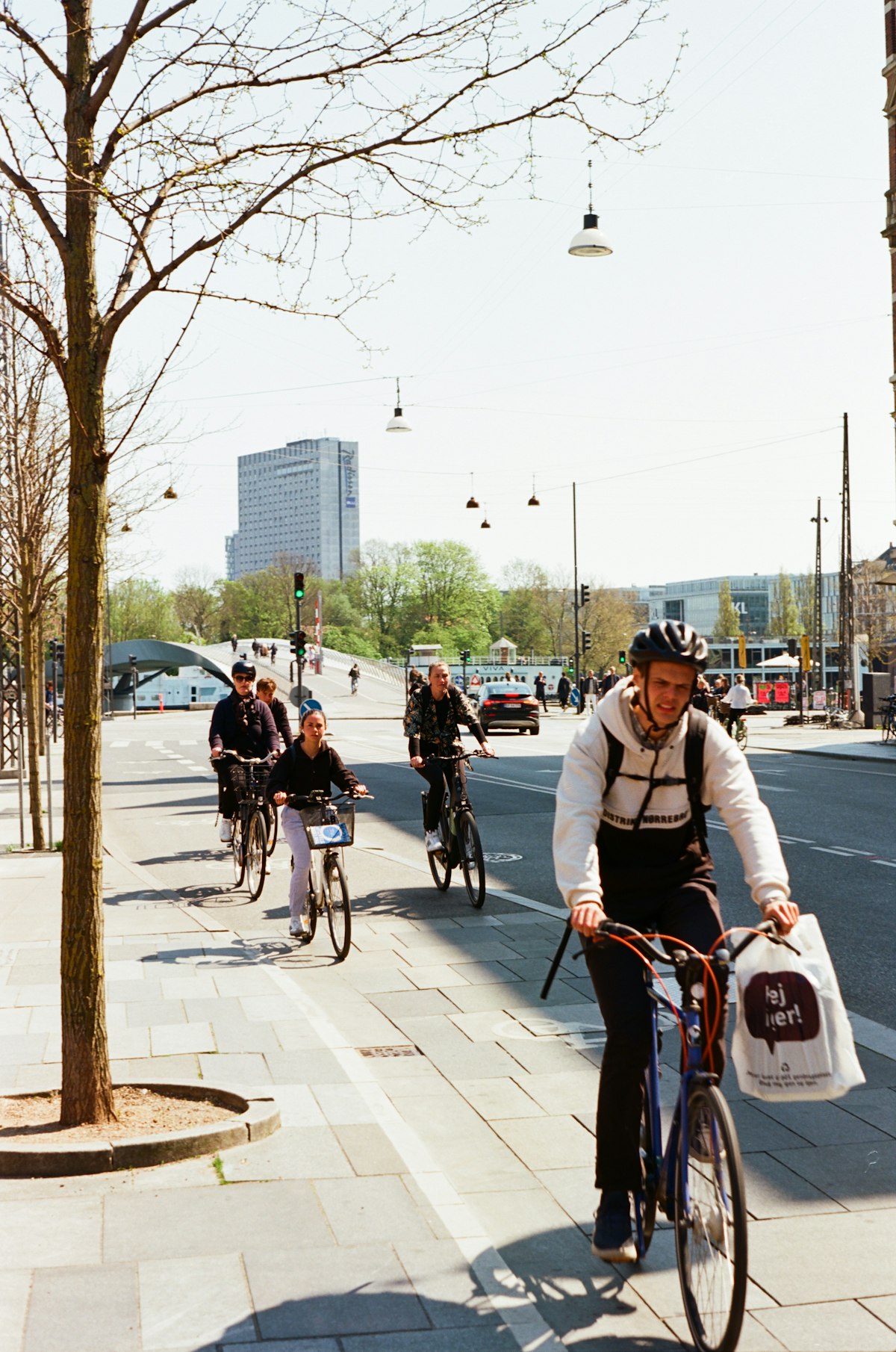 Cyclists riding along a Copenhagen cycle lane on a bright spring day